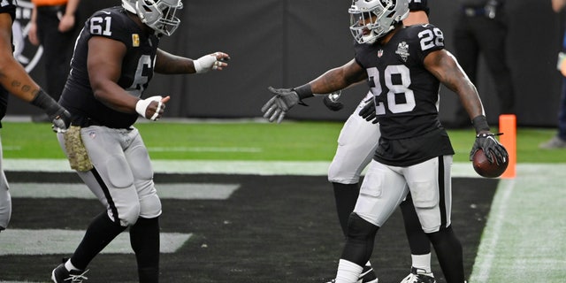 Las Vegas Raiders center Rodney Hudson (61) celebrates after running back Josh Jacobs (28) scored a touchdown against the Denver Broncos during the first half of an NFL football game, Sunday, Nov. 15, 2020, in Las Vegas. (AP Photo/David Becker)