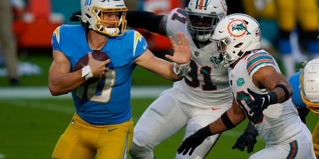 Los Angeles Chargers quarterback Justin Herbert (10) is under pressure by Miami Dolphins defensive back Nik Needham (40) and defensive end Emmanuel Ogbah (91) during the first half of an NFL football game, 일요일, 11 월. 15, 2020, in Miami Gardens, Fla. (AP Photo/Wilfredo Lee)