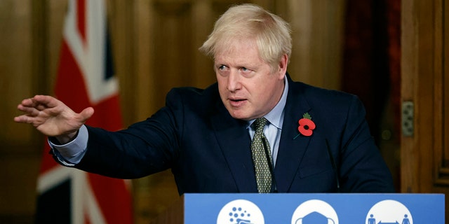 FILE - In this Nov. 9, 2020 file photo Britain's Prime Minister Boris Johnson reaches out during a virtual press conference on the coronavirus pandemic at 10 Downing Street in central London. Johnson is self-isolating after being told he came into contact with someone who tested positive for the coronavirus, officials said Sunday Nov. 15. "He will carry on working from Downing Street, including on leading the government's response to the coronavirus pandemic," a statement from his office said. (Tolga Akmen / Pool via AP, File)