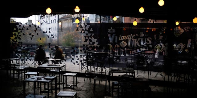 People sit in an empty cafe in downtown Belgrade, Serbia, Monday, Nov. 16, 2020. 