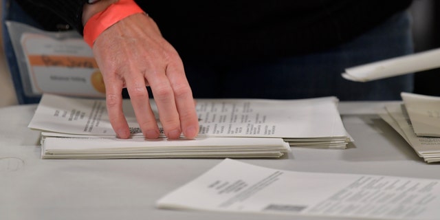 Cobb County Election officials handle ballots during an audit, Monday, Nov. 16, 2020, in Marietta, Ga. (AP Photo/Mike Stewart)