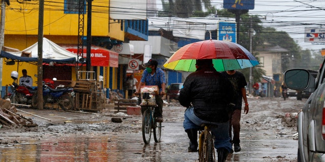 Locals move on street barely cleared from the debris of the last storm, before Hurricane Iota makes landfall in La Lima, Honduras, Monday, November 16, 2020. Hurricane Iota rapidly strengthened Monday into a Category 5 storm that is likely to bring catastrophic damage to the same part of Central America already battered by a powerful Hurricane Eta less than two weeks ago. (AP Photo/Delmer Martinez)