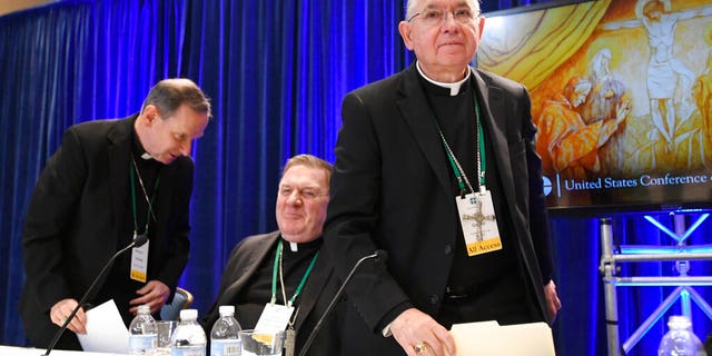 FILE: Archbishop Jose H. Gomez, right, of Los Angeles, with Bishop Michael F. Burbidge, left, of Arlington, Va., and Cardinal Joseph William Tobin, of Newark, N.J., exits a news conference during their Fall General Assembly in Baltimore.