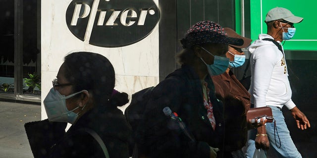 In this Nov. 9, 2020, file photo, pedestrians walk past Pfizer world headquarters in New York.