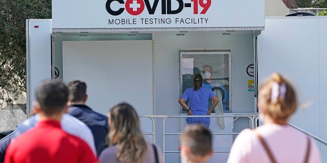 People lined up to receive a COVID-19 test, Wednesday, Nov.  18, 2020, in Opa-Locka, Fla.