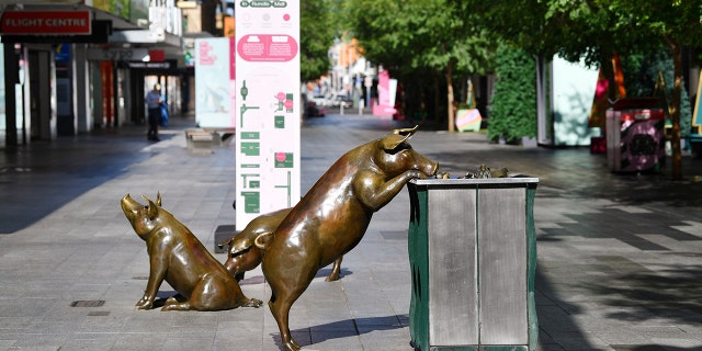 Sculptures of pigs are displayed in a nearly empty pedestrian mall in Adelaide, Australia, Thursday, Nov. 19, 2020. (David Mariuz/AAP Image via AP)