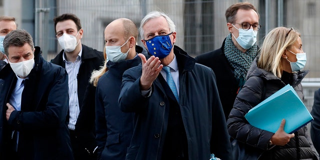 In this file photo dated Thursday, Nov. 12, 2020, European Commission's Head of Task Force for Relations with the United Kingdom Michel Barnier, centre, leaves the Conference Centre in London with unidentified members of his team. The Brexit trade negotiations have been suspended Thursday Nov. 19, 2020, at a crucial stage because an EU negotiator has tested positive for the coronavirus and EU chief negotiator Michel Barnier said that “we have decided to suspend the negotiations at our level for a short period.” (AP Photo/Frank Augstein, FILE)