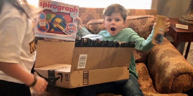 Chip Matthews, 6, opens a birthday present at his home in Opelika, Ala., on Thursday, Nov. 5, 2020. Matthews was given an extra birthday surprise when postal worker, Tawanna Purter, gave him $2 as a gift. (Bonnie Matthews via AP)