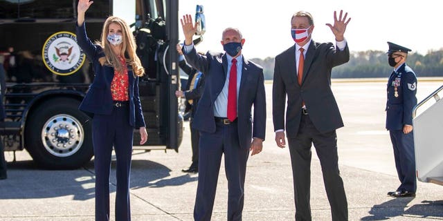 Vice President Mike Pence, center, Senator Kelly Loeffler to the left and Senator David Perdue to the right, waving to people at Dobbins Air Reserve Base, Marietta, Ga., November 20, 2020)