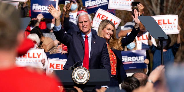 Vice President Mike Pence and Kelly Loeffler wave to the crowd during a Defend the Majority Rally, Friday, Nov. 20, 2020 in Canton, Ga. U.S. Sen. Kelly Loeffler waves behind Pence. (AP Photo/Ben Gray)