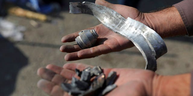 An Afghan man holds rocket shell after a rocket attack in Kabul, 阿富汗, 星期六, 十一月. 21, 2020. Mortar shells slammed into different parts of the Afghan capital on Saturday, killing several and wounding dozens of people, an official said. (AP Photo/Rahmat Gul)