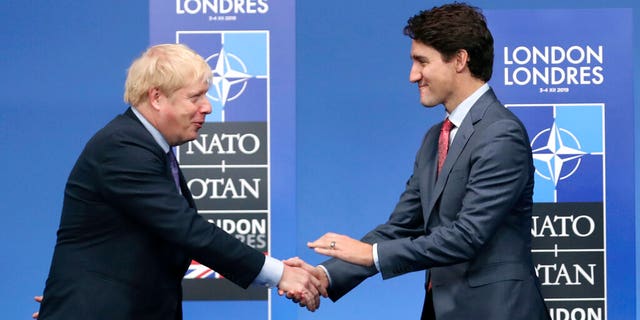 In this Dec. 4, 2019 photo, British Prime Minister Boris Johnson, left, welcomes Canadian Prime Minister Justin Trudeau during official arrivals for a NATO leaders meeting at The Grove hotel and resort in Watford, Hertfordshire, England. (AP Photo/Francisco Seco, File)