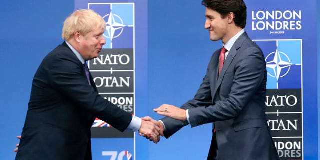 In this Dec. 4, 2019 photo, British Prime Minister Boris Johnson, left, welcomes Canadian Prime Minister Justin Trudeau during official arrivals for a NATO leaders meeting at The Grove hotel and resort in Watford, Hertfordshire, England. (AP Photo/Francisco Seco, File)