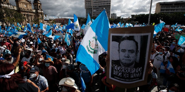Protesters gather outside Congress in Guatemala City, Saturday, Nov. 21, 2020. Hundreds of protesters were protesting in various parts of the country Saturday against Guatemalan President Alejandro Giammattei and members of Congress for the approval of the 2021 budget that reduced funds for education, health and the fight for human rights. (AP Photo/Moises Castillo)