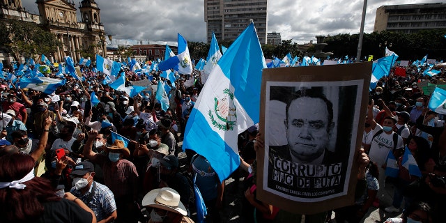 Protesters gather outside Congress in Guatemala City, Saturday, Nov. 21, 2020. Hundreds of protesters were protesting in various parts of the country Saturday against Guatemalan President Alejandro Giammattei and members of Congress for the approval of the 2021 budget that reduced funds for education, health and the fight for human rights. (AP Photo/Moises Castillo)