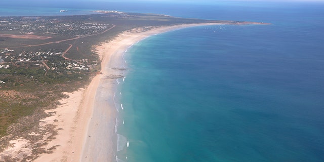 This aerial photo shows Cable Beach and the town of Broome, Western Australia, on June 24, 2014. A 55-year-old man died Sunday, Nov. 22, 2020 after being attacked by a shark off Cable Beach, a popular tourist spot on Australia’s Indian Ocean coast, the eighth fatality in the country this year. (Kim Christian/AAP Image via AP)