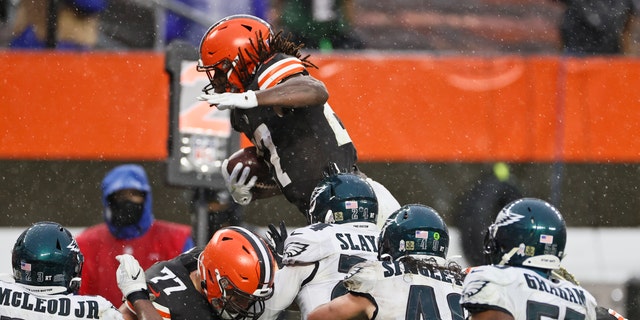 Cleveland Browns running back Kareem Hunt, top, rushes for a 5-yard touchdown during the second half of an NFL football game against the Philadelphia Eagles, Sunday, Nov. 22, 2020, in Cleveland. (AP Photo/Ron Schwane)