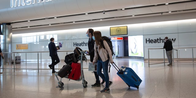 FILE - In this file photo dated Monday, June 8, 2020, passengers wearing face masks arrive at London's Heathrow Airport. (AP Photo/Matt Dunham, File)