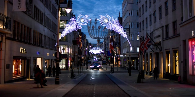 Christmas lights are lit up on New Bond Street in Mayfair, London, Tuesday, Nov. 24, 2020. Haircuts, shopping trips and visits to the pub will be back on the agenda for millions of people when a four-week lockdown in England comes to an end next week, British Prime Minister Boris Johnson said Monday. (AP Photo/Alberto Pezzali)