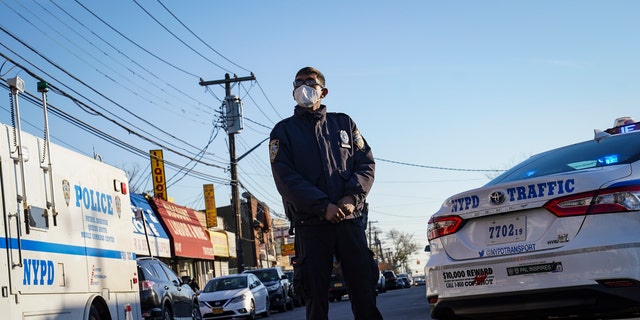 Police maintain a perimeter outside a crime scene, Tuesday, Nov. 24, 2020, in the Queens borough of New York. (AP Photo/John Minchillo)
