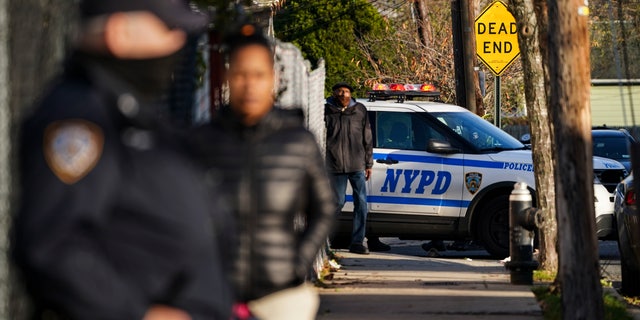 NYPD officers hold a perimeter outside a crime scene in the Queens borough of New York. 