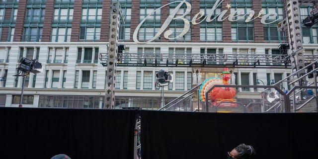 Pedestrians walk past black curtains along 34th Street meant to block the view of a pre-taping of the Macy's Thanksgiving Day Parade in front of the flagship store in New York, Wednesday, Nov. 25, 2020. (AP Photo/Mary Altaffer)