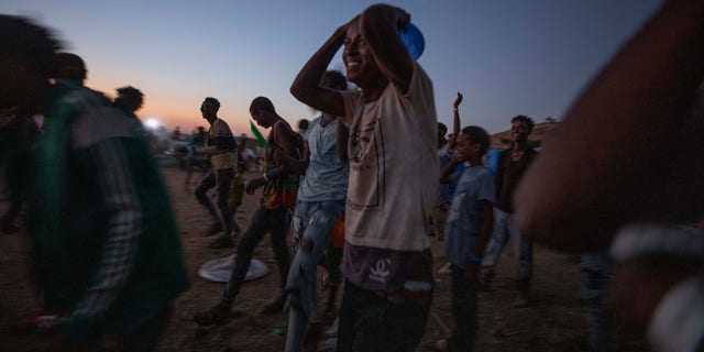 Tigray men who fled the conflict in Ethiopia's Tigray region, run to recieve cooked rice from charity organization Muslim Aid, at Umm Rakouba refugee camp in Qadarif, eastern Sudan, Friday, Nov. 27, 2020. Ethiopian Prime Minister Abiy Ahmed again ruled out dialogue with the leaders of the defiant Tigray region Friday but said he was willing to speak to representatives 