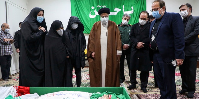 Iran's Judiciary Chief Ayatollah Ebrahim Raisi pays his respect to the body of slain scientist Mohsen Fakhrizadeh among his family, in Tehran, Iran, Saturday, Nov. 28, 2020. Iranian officials have blamed Israel for the killing of Fakhrizadeh who led Tehran's disbanded military nuclear program. (Mizan News Agency via AP)