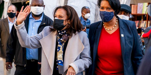 Vice President-elect Kamala Harris, center left, accompanied by Washington Mayor Muriel Bowser, right, waves while visiting the Downtown Holiday Market, Saturday, Nov. 28, 2020, in Washington.