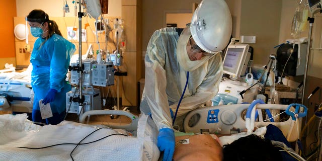 FILE: Dr. Rafik Abdou checks on a COVID-19 patient at Providence Holy Cross Medical Center in the Mission Hills section of Los Angeles.