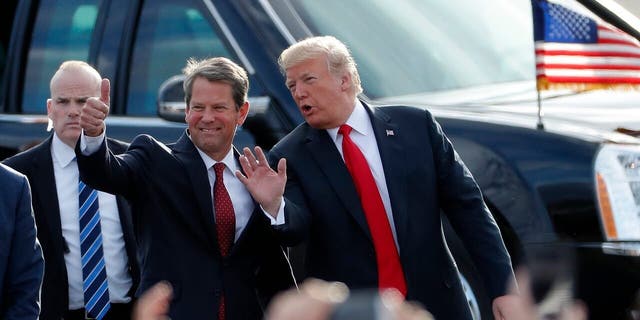 FILE - In this Nov. 4, 2018, file photo, then-Georgia Republican gubernatorial candidate Brian Kemp, left, walks with President Donald Trump as Trump arrives for a rally in Macon , Ga. President Trump said Sunday, Nov. 29, 2020 he was "ashamed" for endorsing the Republican governor of Georgia after he lost in the state to Democrat Joe Biden. Trump said on Fox News that Gov. Brian Kemp has "done absolutely nothing" to question the state’s results.. (AP Photo/John Bazemore, File)