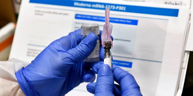 In this July 27, 2020, file photo, nurse Kathe Olmstead prepares a shot that is part of a possible COVID-19 vaccine, developed by the National Institutes of Health and Moderna Inc., in Binghamton, N.Y. (AP Photo/Hans Pennink, File)