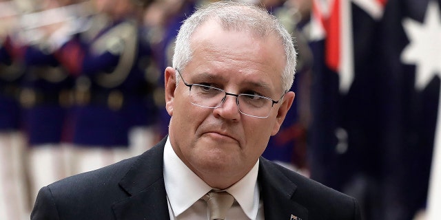 FILE - In this Nov. 17, 2020, file photo, Australian Prime Minister Scott Morrison reviews an honor guard during a ceremony ahead of a meeting at Japanese Prime Minister Yoshihide Suga's official residence in Tokyo. Morrison said Monday, Nov. 30, 2020, a tweet by a Chinese official which shows a fake image of an Australian soldier appearing to slit a child's throat is “truly repugnant." (Kiyoshi Ota/Pool Photo via AP, File)