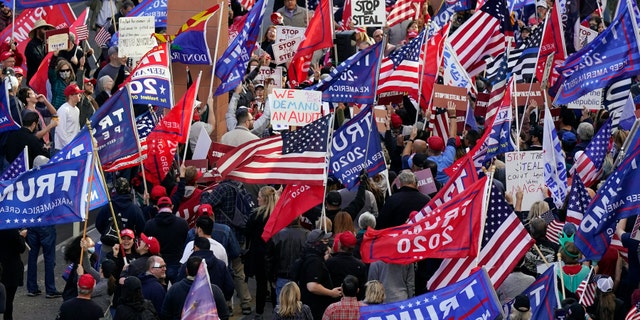 Supporters of President Donald Trump protest in front of a local hotel where Arizona Republicans have scheduled a meeting as a "fact-finding hearing" to discuss the election, featuring members of Trump's legal team and Arizona legislators, Monday, Nov. 30, 2020, in Phoenix. (AP Photo/Ross D. Franklin)