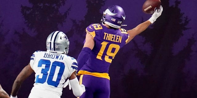 Minnesota Vikings wide receiver Adam Thielen (19) catches a 2-yard touchdown pass ahead of Dallas Cowboys cornerback Anthony Brown (30) during the second half of an NFL football game, Sunday, Nov. 22, 2020, in Minneapolis.