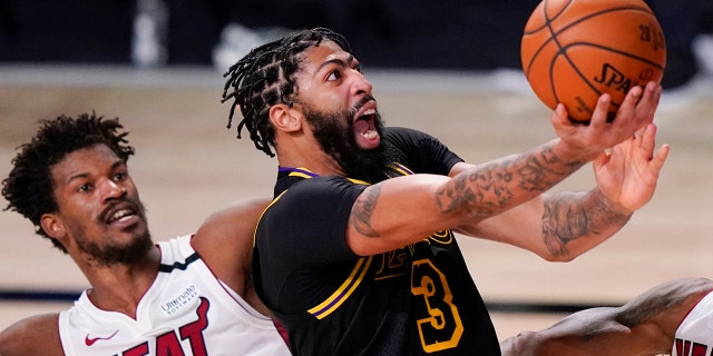 In this Oct. 9, 2020, file photo, Los Angeles Lakers forward Anthony Davis shoots past Miami Heat forward Jimmy Butler during the second half in Game 5 of the NBA Finals in Lake Buena Vista, Fla. AP Photo/Mark J. Terrill, File)