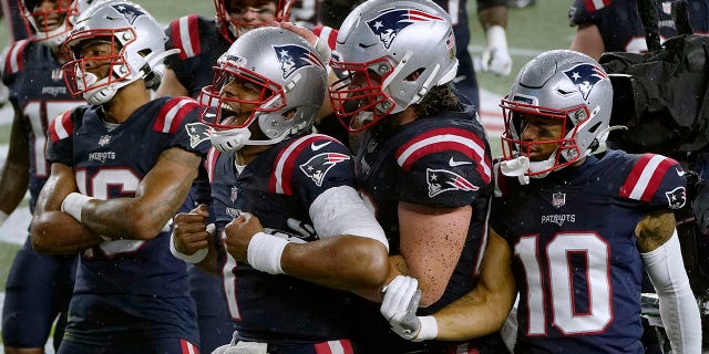 New England Patriots quarterback Cam Newton, center, celebrates his rushing touchdown with teammates in the second half of an NFL football game against the Baltimore Ravens, Sunday, Nov. 15, 2020, in Foxborough, Mass.