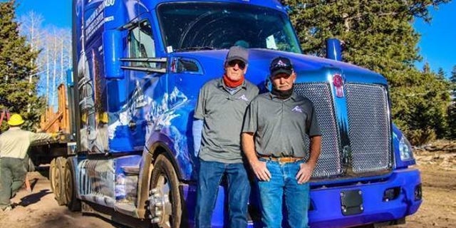 Theron Schmalzried, left, and Butch Hanna, right, the two professional truck drivers transporting the U.S. Capitol Christmas tree, pictured at the tree cutting ceremony in the Grand Mesa, Uncompahgre and Gunnison (GMUG) National Forests on November 5. Photo credit: James Edward Mills