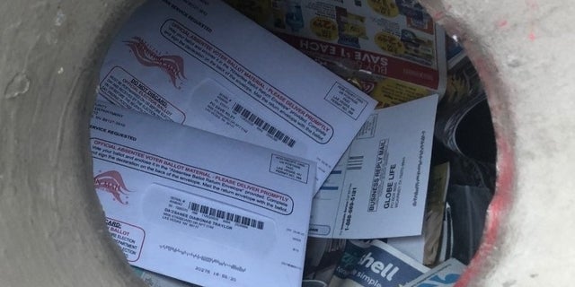Mass-mail-in ballots sit atop junk mail in a trash can beside a Las Vegas, Nev., apartment building, October 2020. Photo courtesy of Jim Murphy.