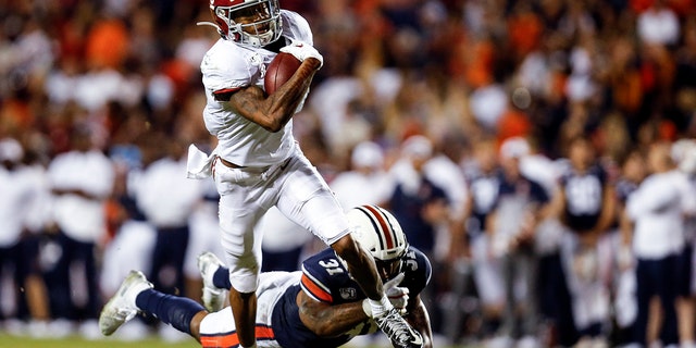 In this Nov. 30, 2019, file photo, Alabama wide receiver DeVonta Smith (6) catches a pass as Auburn linebacker Chandler Wooten (31) tries to tackle him during the second half of an NCAA college football game in Auburn, Ala. (AP Photo/Butch Dill, File)