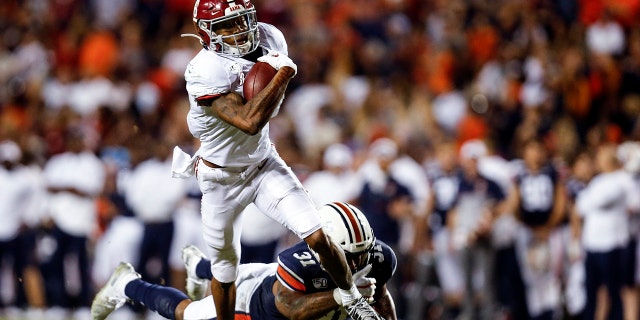 Dans cette photo d'archive du 30 novembre 2019, le receveur large de l'Alabama DeVonta Smith (6) attrape une passe alors que le secondeur d'Auburn Chandler Wooten (31) tente de l'attaquer pendant la seconde moitié d'un match de football universitaire de la NCAA à Auburn, en Ala. AP Photo / Butch Dill, fichier)