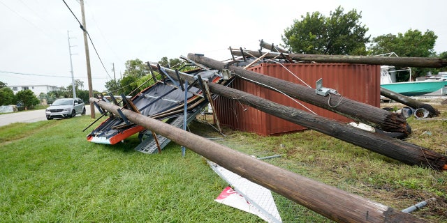 An advertising billboard lies on the ground after falling from high winds and rain from Tropical Storm Eta, Monday, Nov. 9, 2020, in Key Largo, Fla. The storm had top sustained winds of 65 mph Sunday night as it crossed over the Florida Keys.