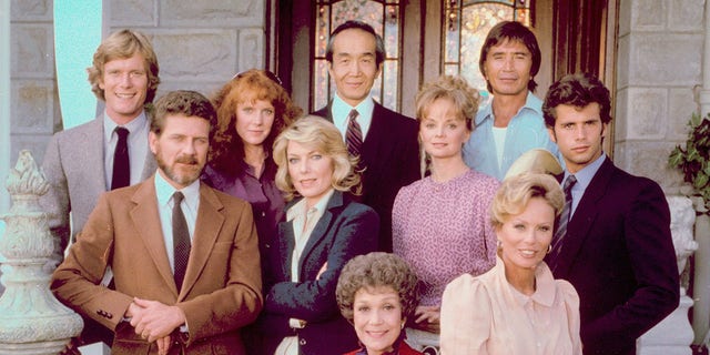 The cast of 'Falcon Crest', clockwise from center front: Jane Wyman, Robert Foxworth, William R. Moses, Jamie Rose, Chao Li Chi, Nick Ramus, Lorenzo Lamas, Abby Dalton (seated on a chair arm), Margaret Ladd (middle row) and Susan Sullivan.  (Photo by CBS Photo Archive / Getty Images)