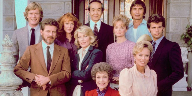 The cast of 'Falcon Crest', clockwise from center front: Jane Wyman, Robert Foxworth, William R. Moses, Jamie Rose, Chao Li Chi, Nick Ramus, Lorenzo Lamas, Abby Dalton (seated on a chair arm), Margaret Ladd (middle row) and Susan Sullivan.  (Photo by CBS Photo Archive / Getty Images)