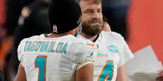 Miami Dolphins quarterback Tua Tagovailoa (1) talks with quarterback Ryan Fitzpatrick (14) during the final seconds of an NFL football game against the Denver Broncos, Sunday, Nov. 22, 2020, in Denver. The Broncos won 20-13. (AP Photo/David Zalubowski)