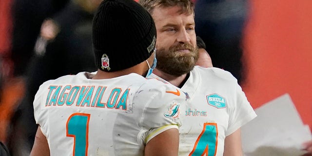Miami Dolphins quarterback Tua Tagovailoa (1) talks with quarterback Ryan Fitzpatrick (14) during the final seconds of an NFL football game against the Denver Broncos, Sunday, Nov. 22, 2020, in Denver. The Broncos won 20-13. (AP Photo/David Zalubowski)