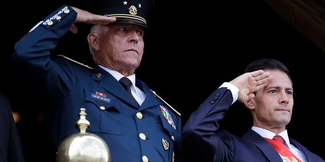 In this Sept. 16, 2016 file photo, Defense Secretary Gen. Salvador Cienfuegos, left, and Mexico's President Enrique Pena Nieto, salute during the annual Independence Day military parade in Mexico City's main square. (AP Photo/Rebecca Blackwell, File)