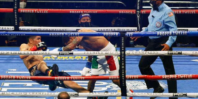 Gervonta Davis, right, pushes Leo Santa Cruz down during a boxing bout Saturday, Oct. 31, 2020, in San Antonio. (AP Photo/Ronald Cortes)