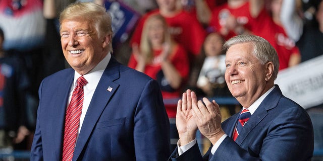 President Trump, left, smiles as he stands alongside Republican Sen.  Lindsey Graham of South Carolina during a Trump campaign rally at the North Charleston Coliseum in North Charleston, SC, Feb. 28, 2020. 