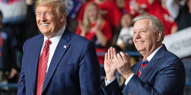 President Donald Trump, left, smiles as he stands alongside Sen. Lindsey Graham, R-S.C., during a Keep America Great campaign rally in North Charleston, S.C., on Feb. 28, 2020.